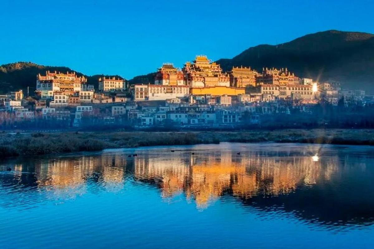 a lit up city on a hill next to a river