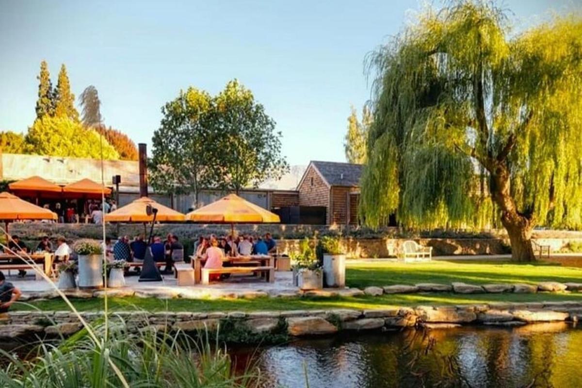 a group of people sitting around a patio near a pond