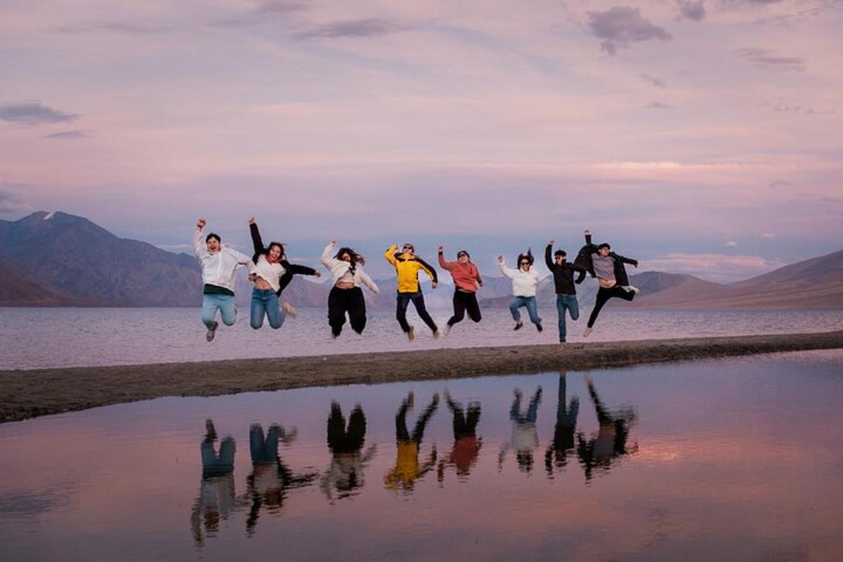 eine Gruppe von Menschen, die am Strand in die Luft springen