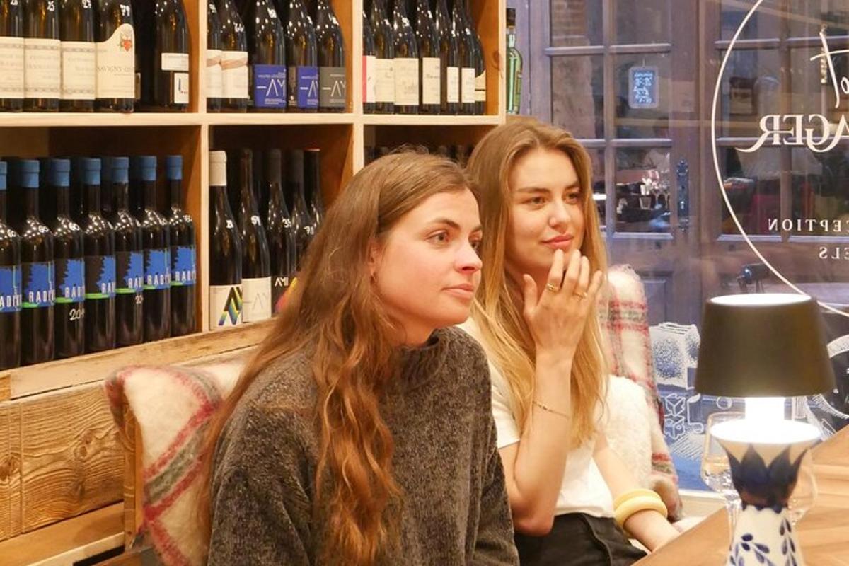 zwei Frauen sitzen an einem Tisch in einem Weinladen