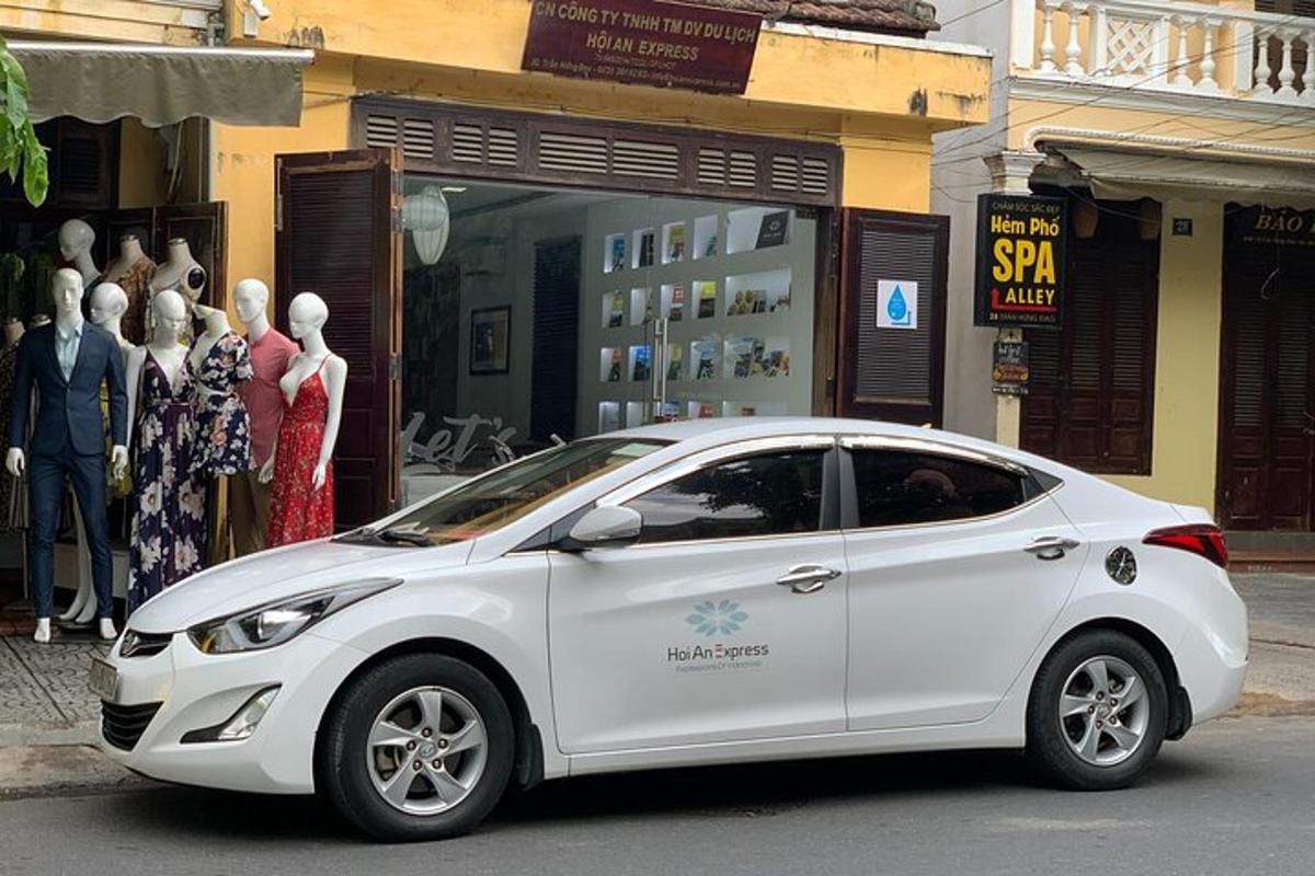 Un coche blanco aparcado delante de una tienda