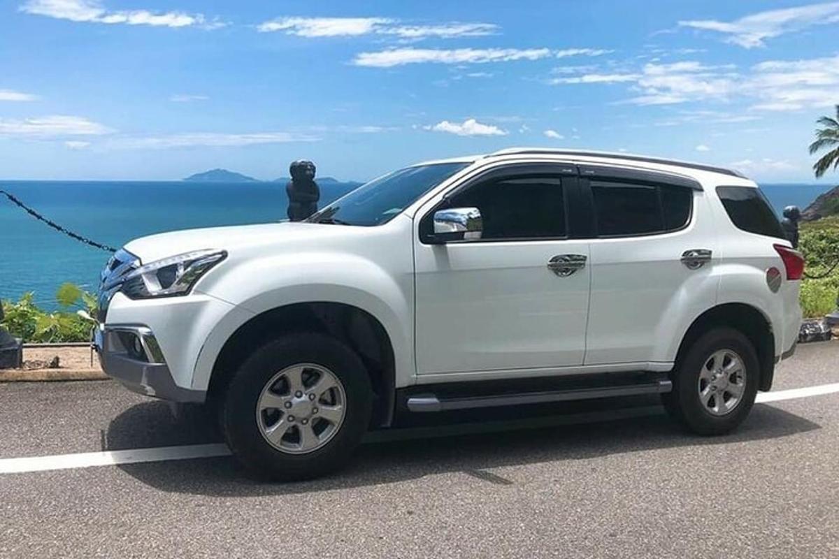 Ένα λευκό SUV παρκαρισμένο σε έναν δρόμο κοντά στον ωκεανό