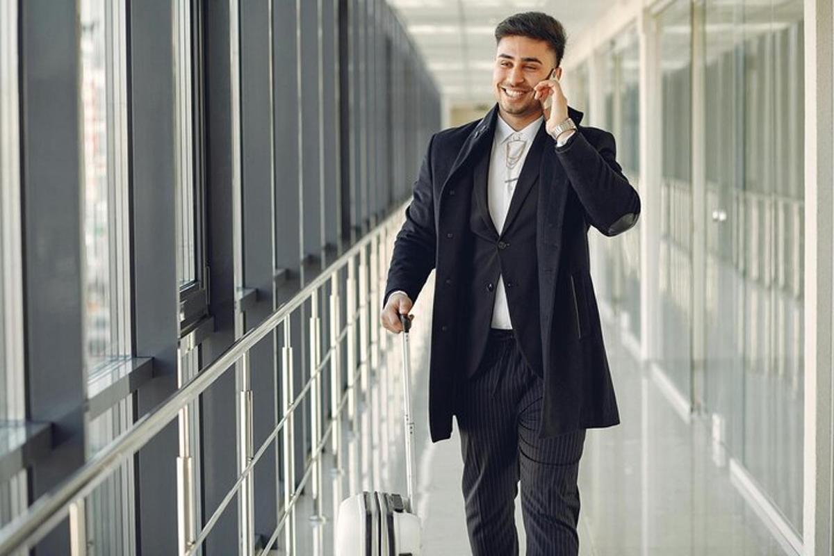 een man in pak die op een mobiele telefoon praat