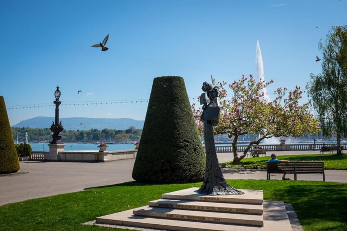 eine Statue einer Frau, die auf einer Bank in einem Park sitzt