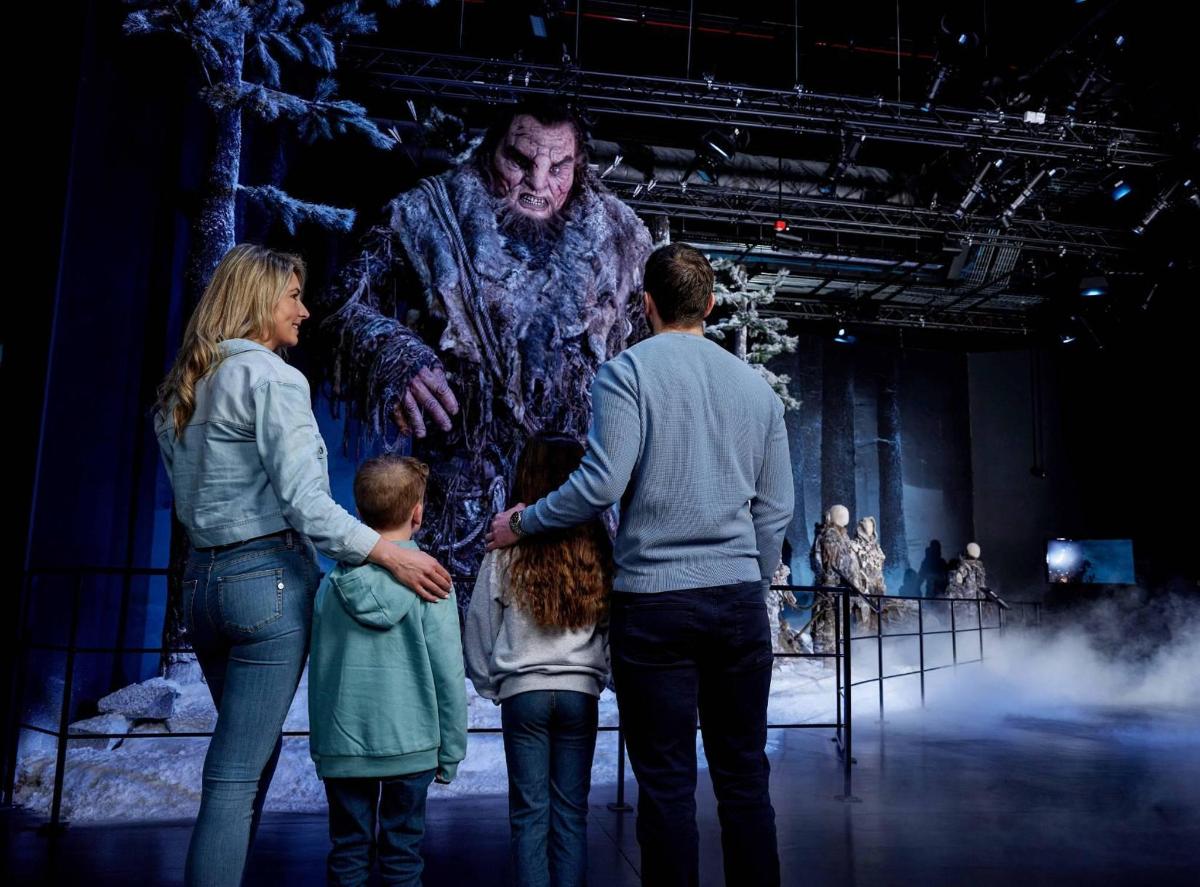 a family looking at a statue of a man on a stage