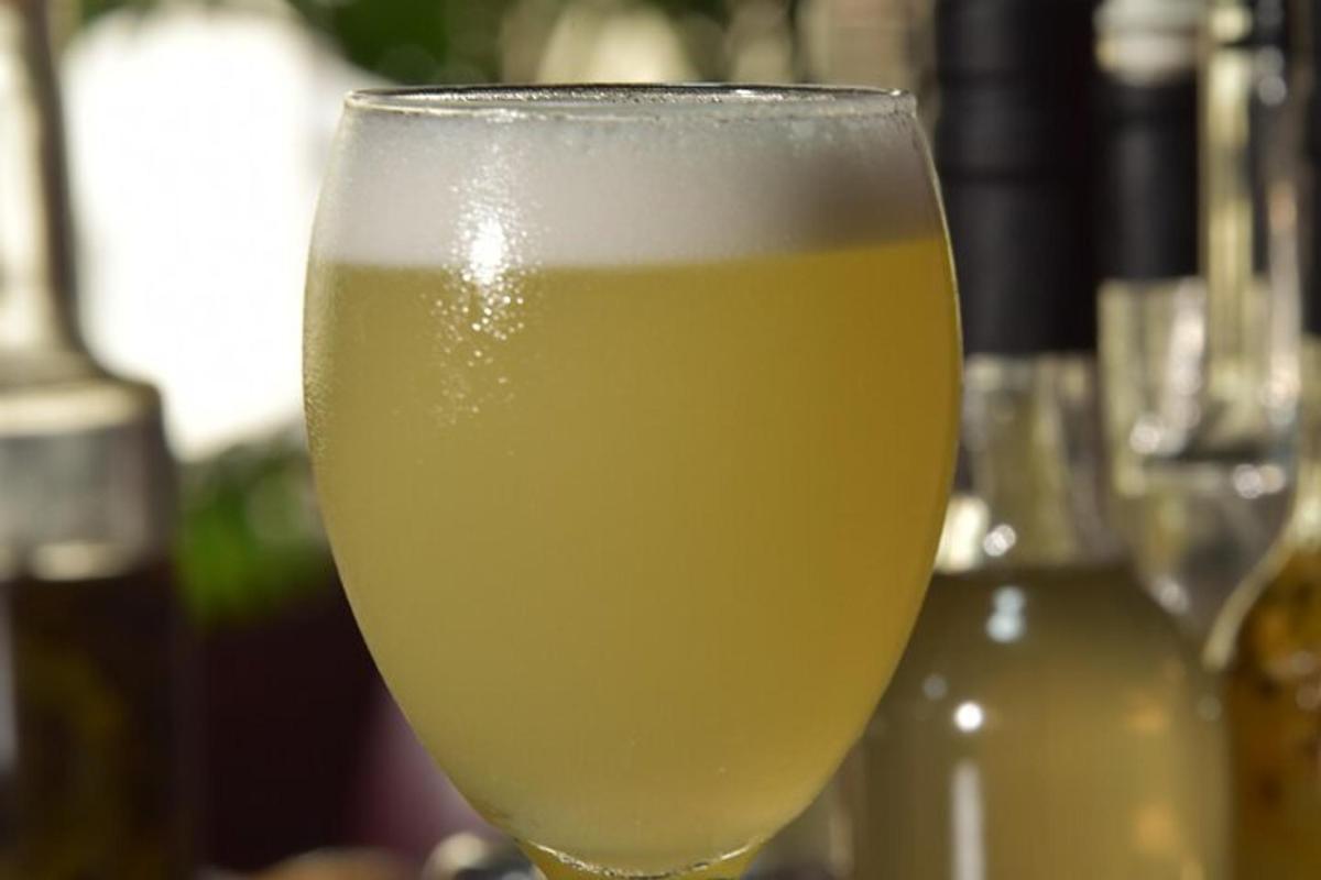 un bicchiere di liquido giallo appoggiato su un tavolo