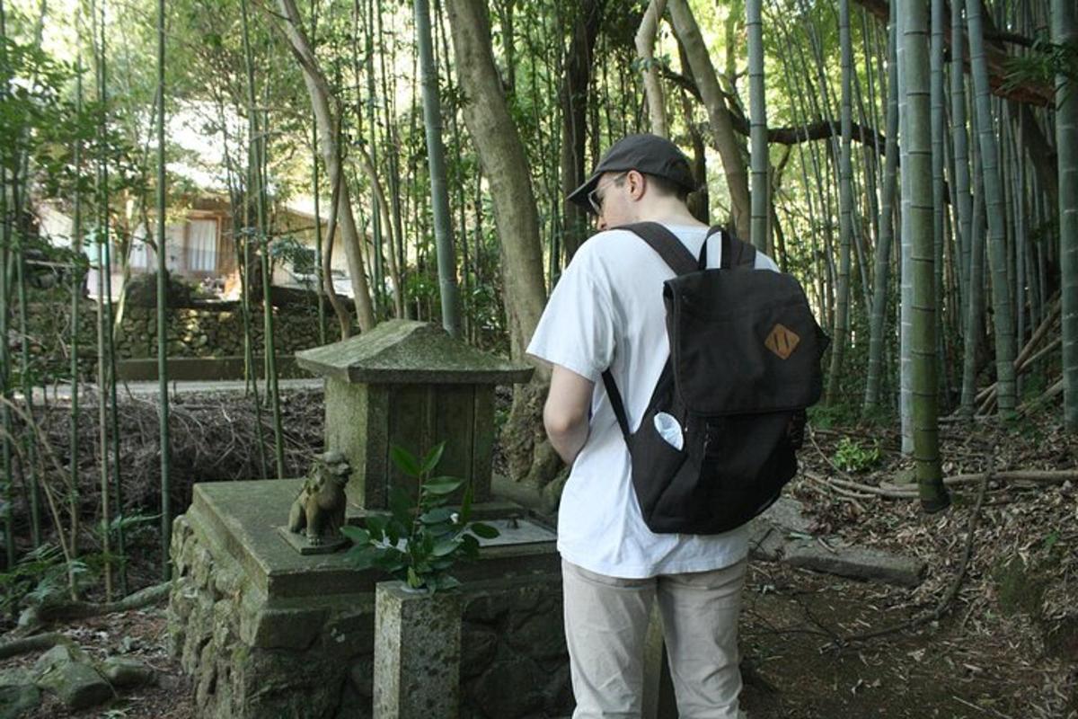 um homem com uma mochila em pé ao lado de um santuário