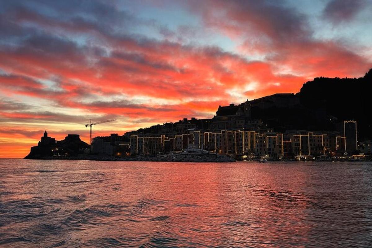 um pôr do sol sobre um corpo d'água com uma cidade
