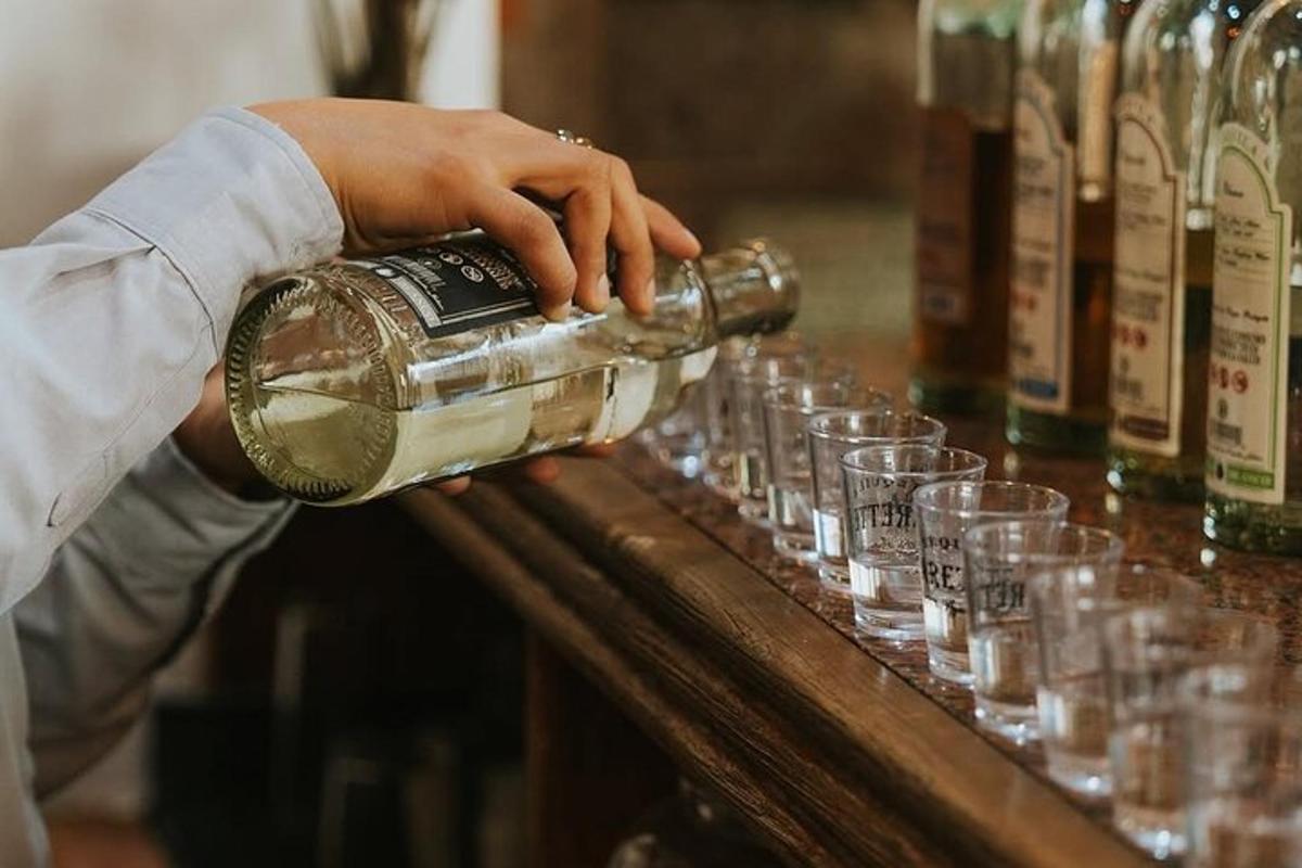バーでボトルから飲み物を注いでいる人