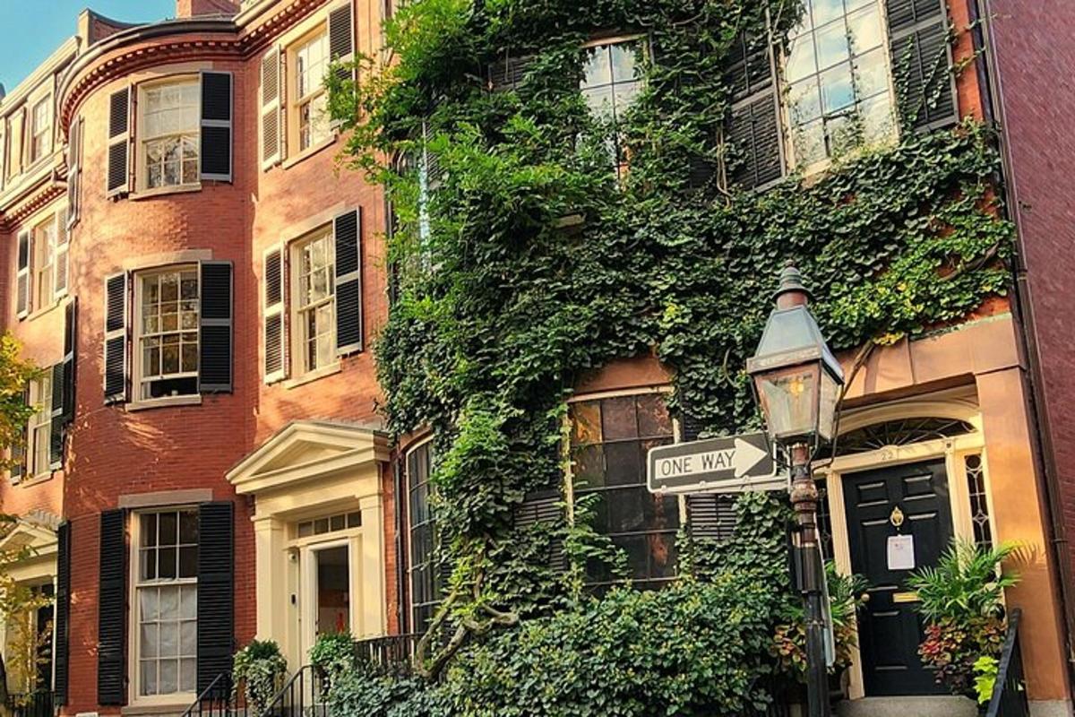 a street sign next to a building with ivy