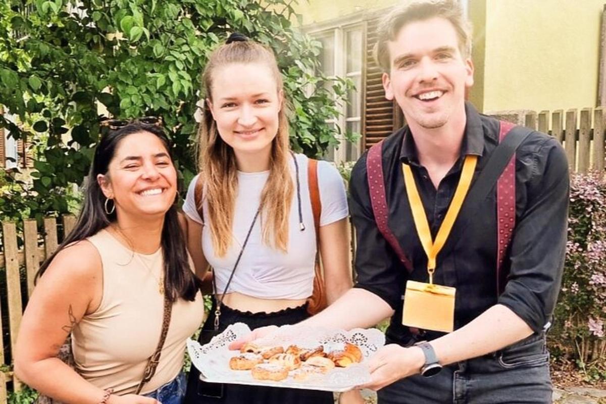 ein Mann und zwei Frauen halten einen Teller mit Donuts