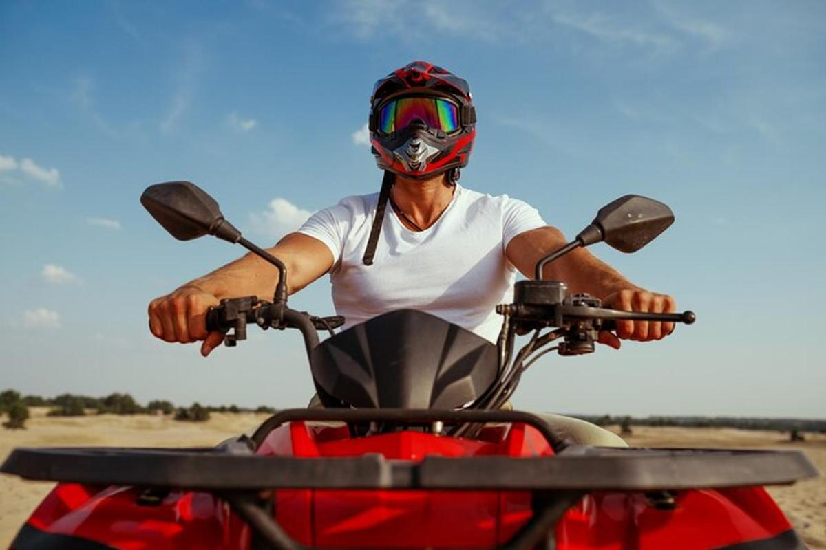 muž s helmou na červené motorce