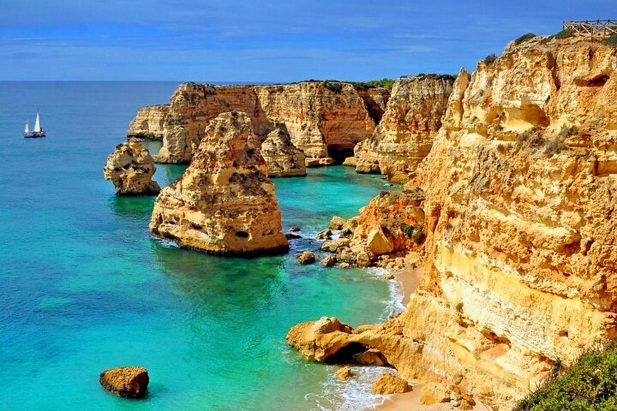 uma praia com pedras e um barco na água