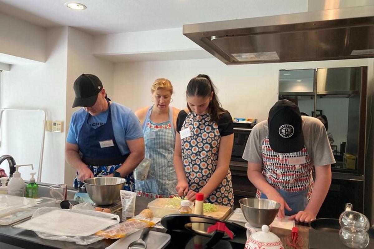 un grup de persones dempeus a la cuina preparant menjar