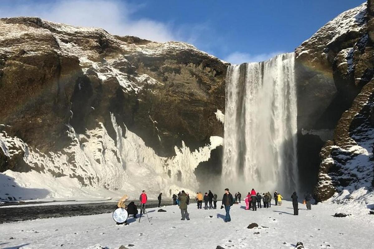 Un grupo de personas de pie frente a una cascada.