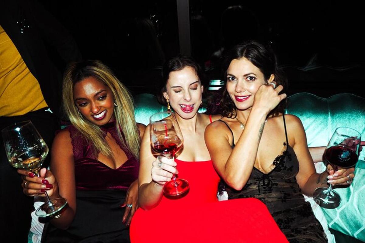 a group of three women holding glasses of wine