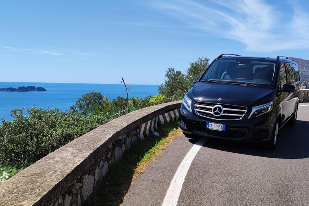 una furgoneta blava conduint per una carretera a prop de l'oceà