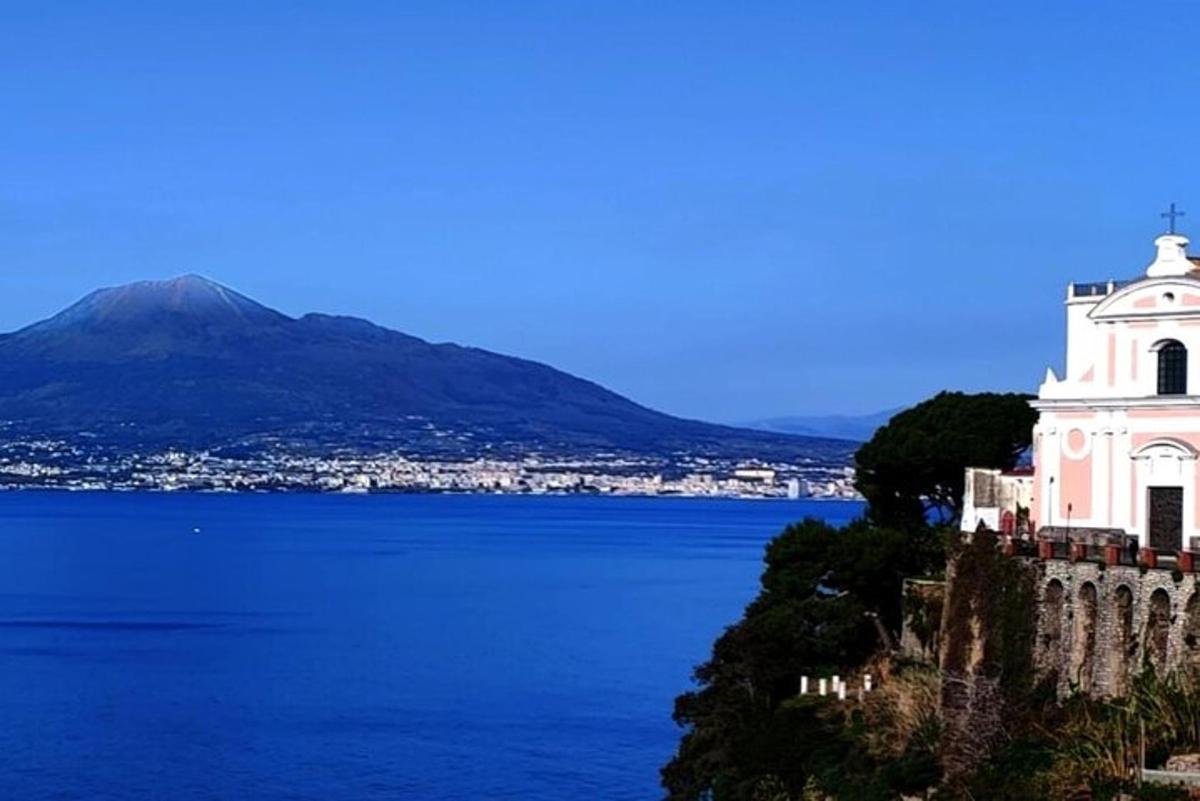 un edifici blanc en un turó al costat d'una massa d'aigua