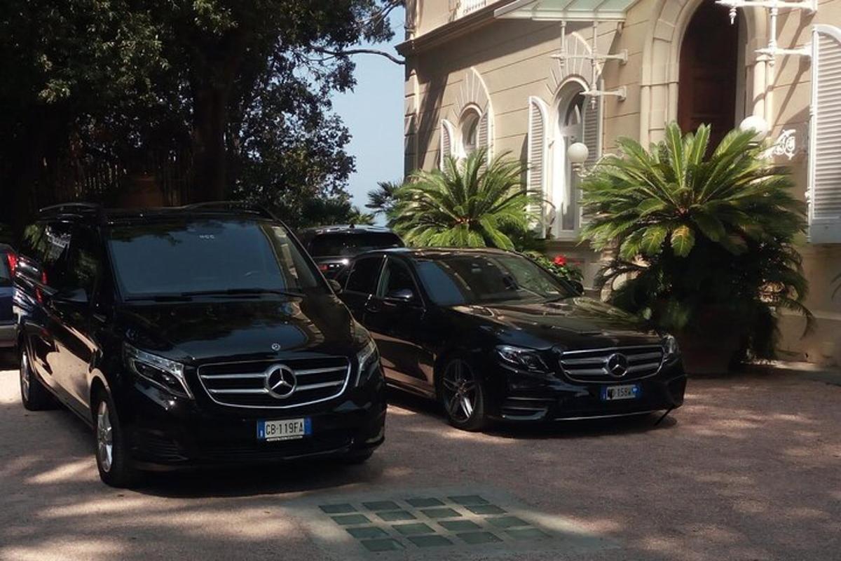 Dos coches estacionados en un estacionamiento frente a un edificio.