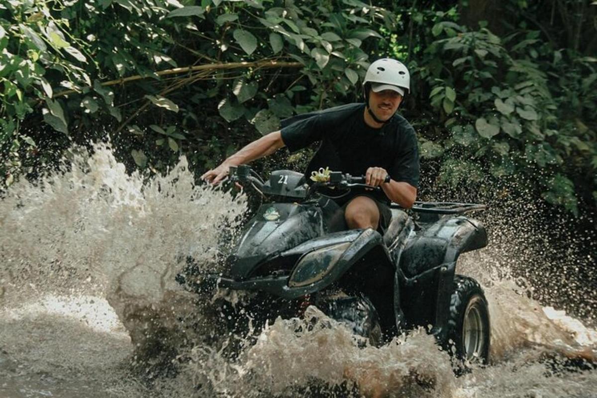 a man riding a four wheeler through the water