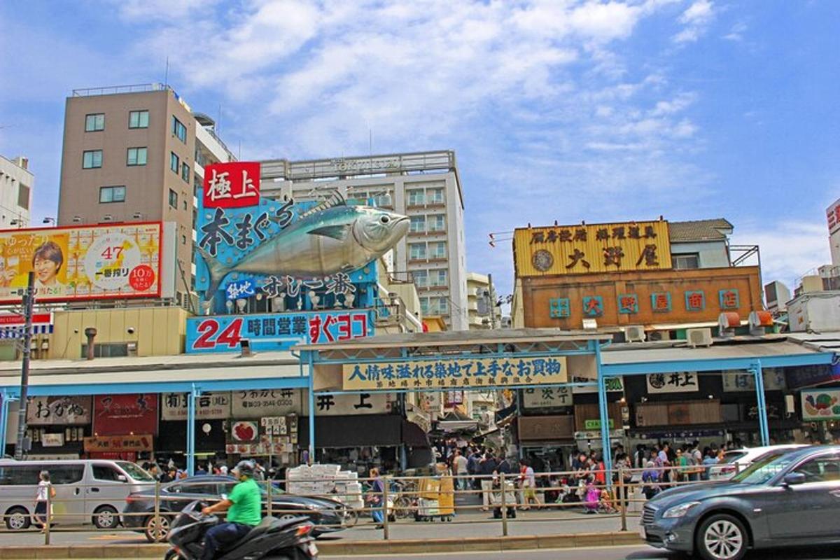 eine belebte Stadtstraße mit Autos und einer Fisch-Werbetafel