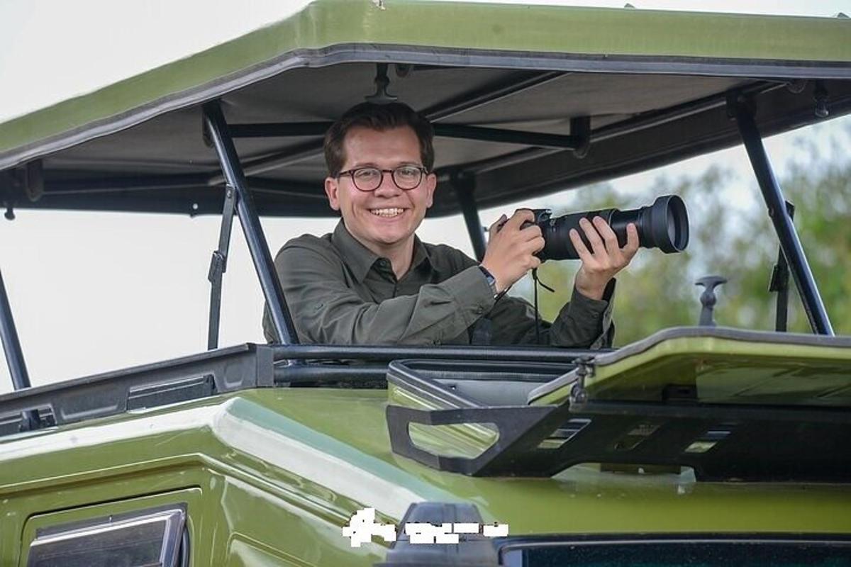 muž držící kameru v zadní části džípu