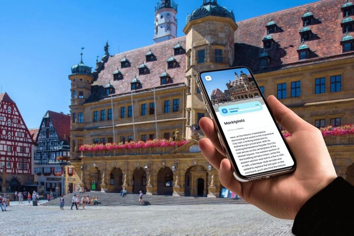eine Person, die ein Mobiltelefon vor einem Gebäude hält