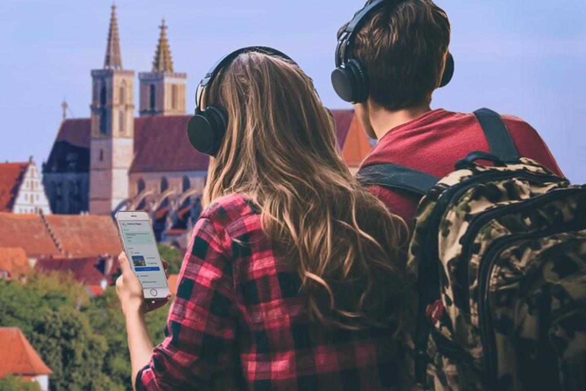 Ein Mann und eine Frau mit Kopfhörern blicken auf eine Stadt