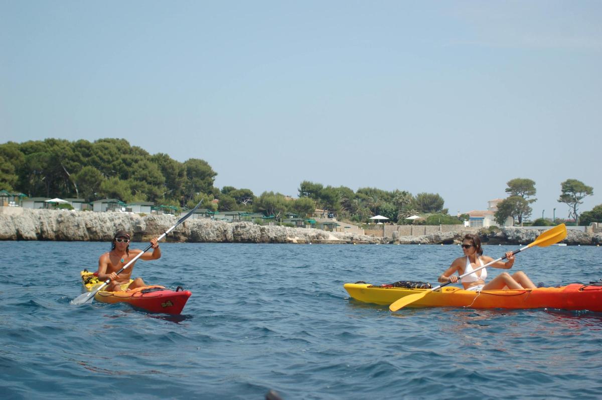 tres personas en kayaks en el agua