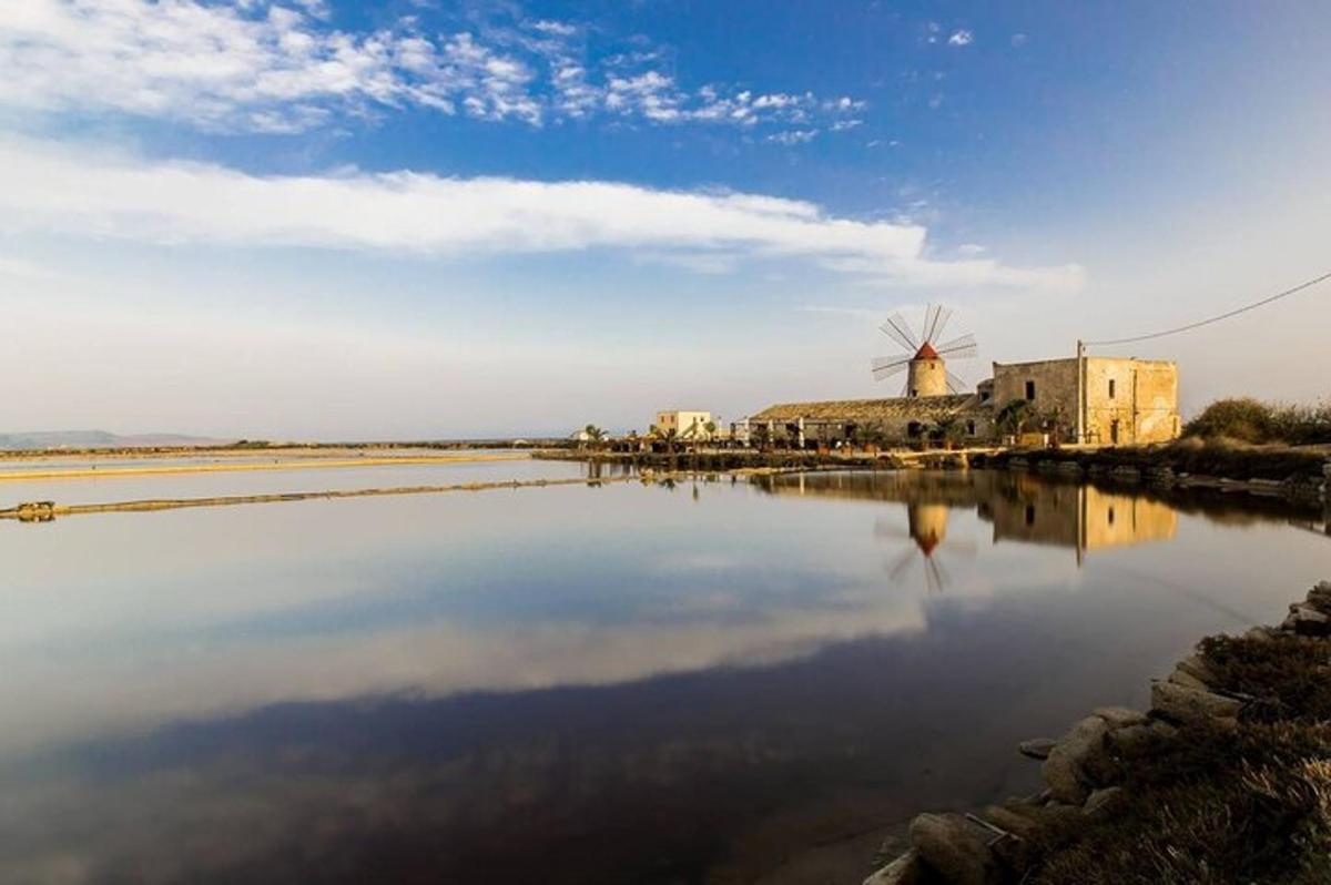una gran massa d'aigua amb un edifici i un molí de vent