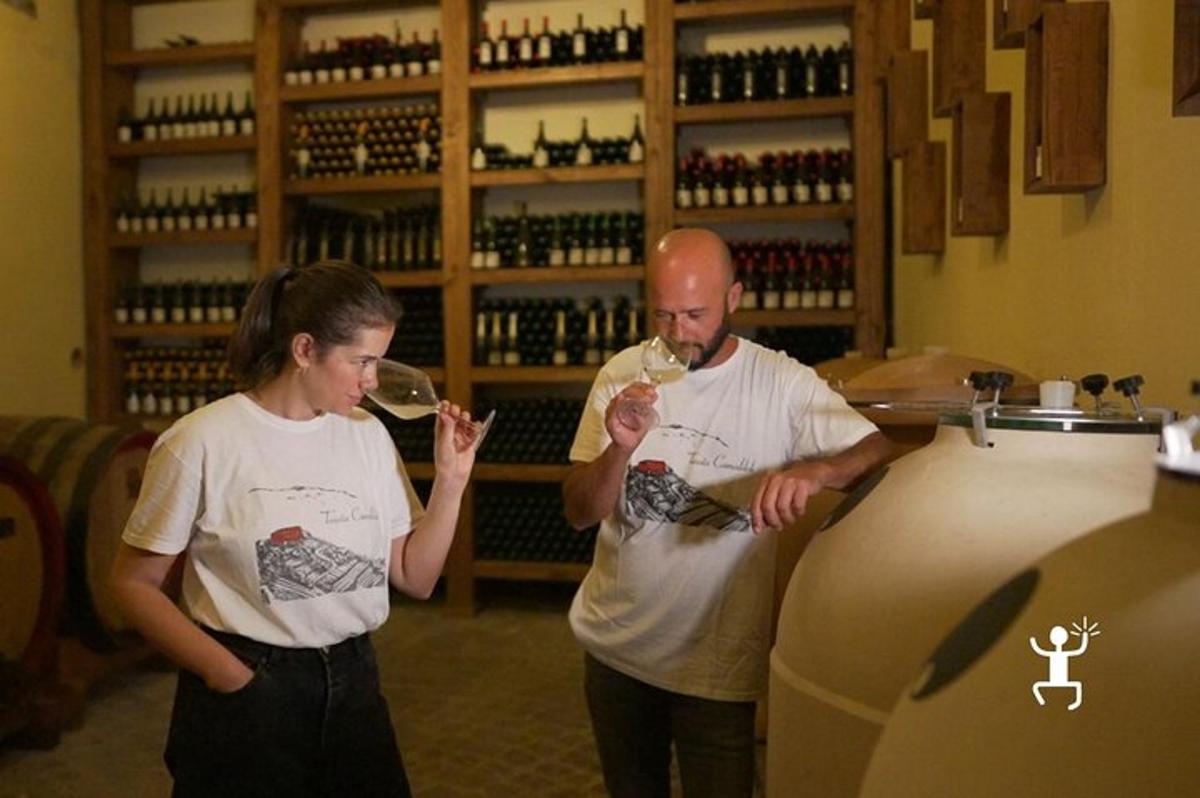 Un hombre y una mujer bebiendo vino en una tienda de vinos.