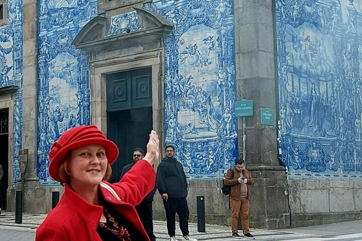 žena se zdviženou rukou před budovou