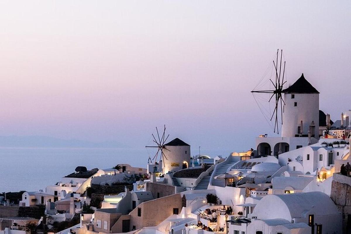 μια πόλη με λευκά κτίρια και ανεμόμυλους σε έναν λόφο