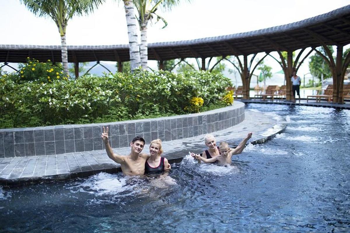 tres persones estan nedant en una piscina