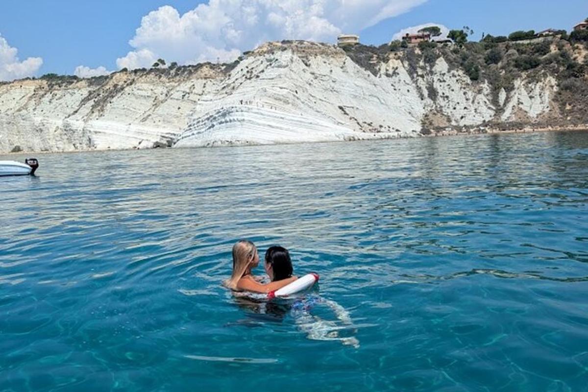 due donne sedute su una tavola da surf in acqua