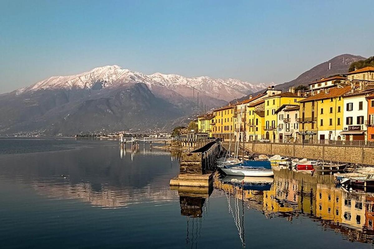 uno specchio d'acqua con barche, edifici e montagne