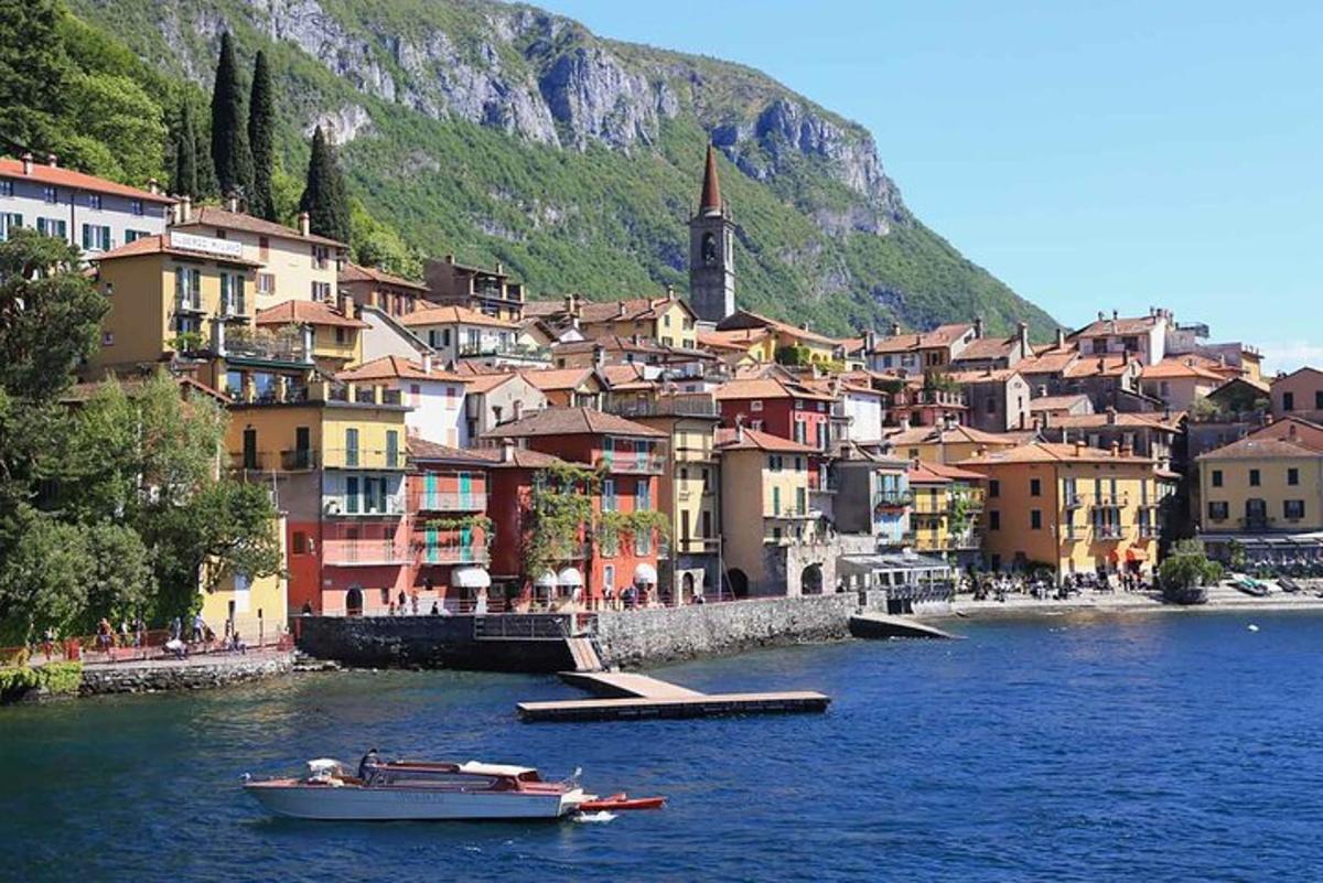 a small boat in the water in front of a town
