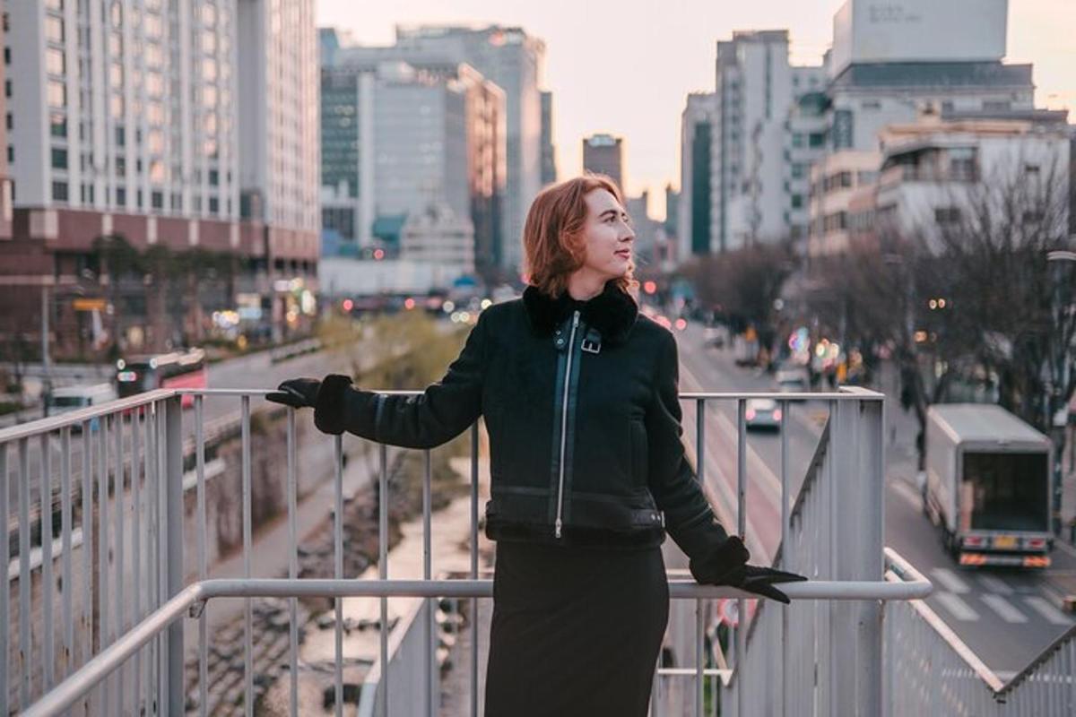 žena stojící na zábradlí ve městě