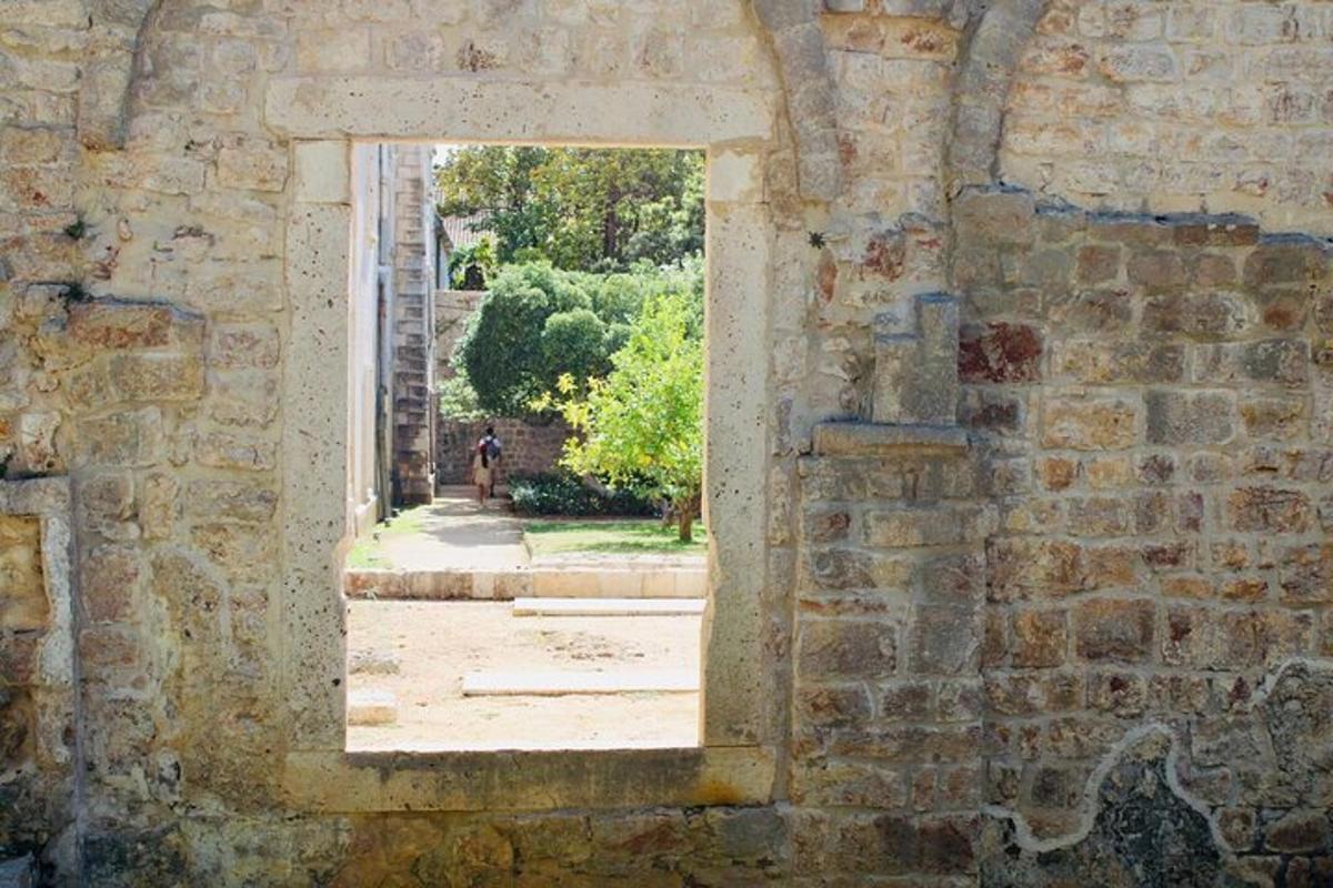 una finestra aperta in un muro di mattoni con una persona in lontananza
