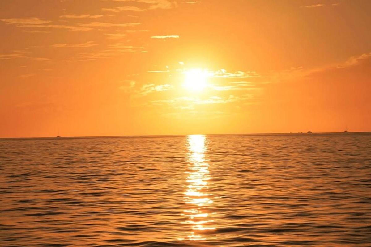 západ slunce nad oceánem se sluncem na obloze