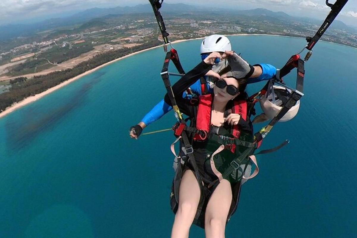 two people are riding in a parachute over the water