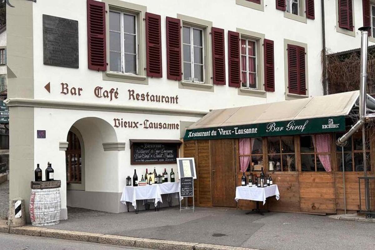 un bar caffetteria ristorante con tavoli di fronte a un edificio