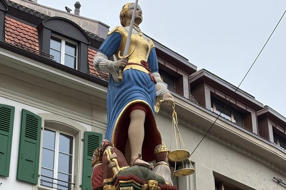 stytta af konu sem stendur ofan á byggingu
