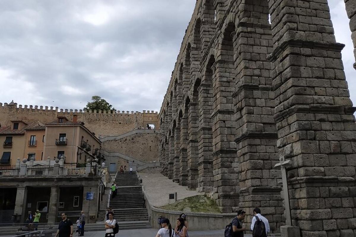 um grupo de pessoas caminhando ao lado de um muro de pedra