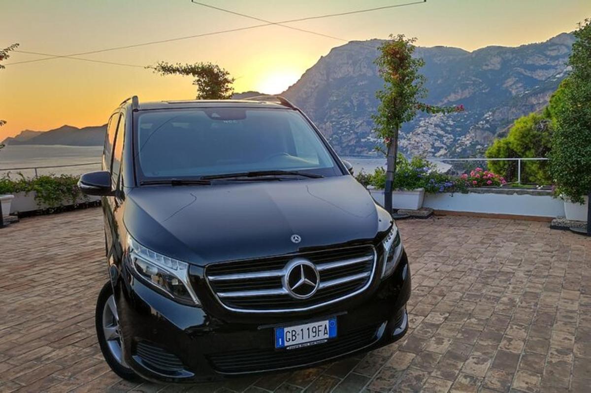 un cotxe Mercedes Benz negre aparcat en un camí d'entrada