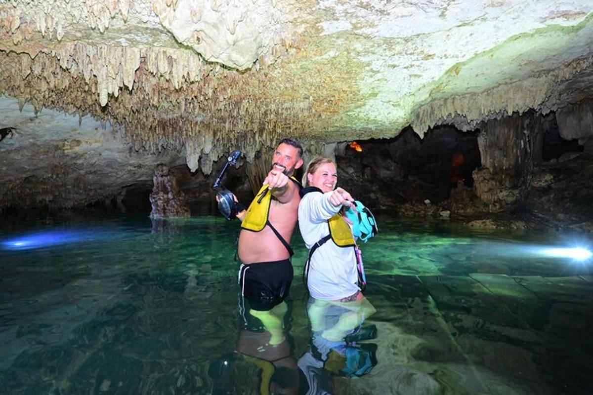 two men standing in the water in a cave