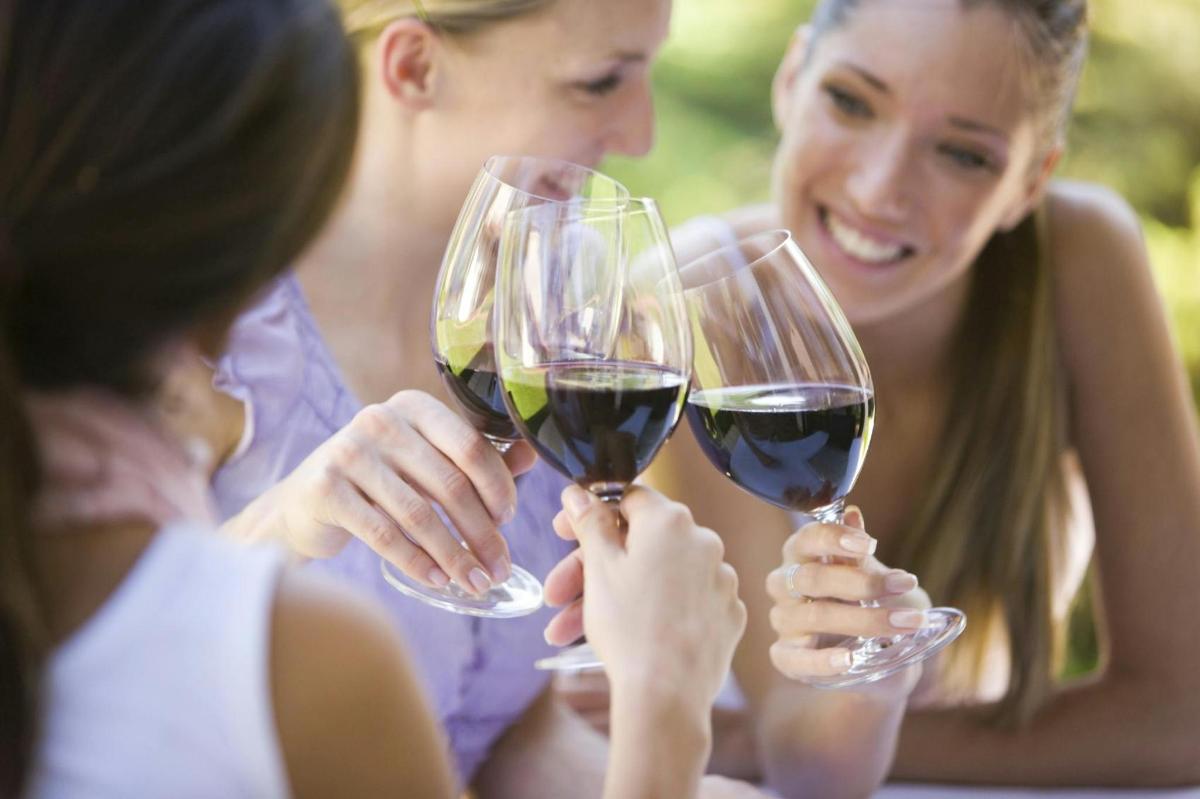 a group of women holding up wine glasses