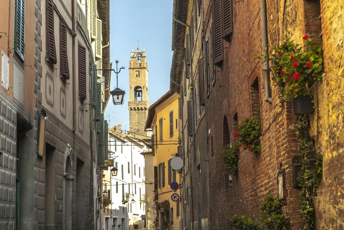 un vicolo con una torre dell'orologio in lontananza