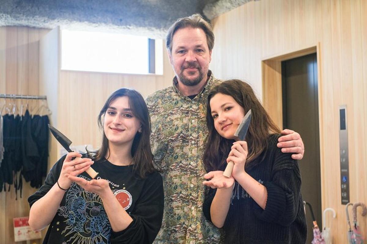 egyenruhás férfi áll két nő mellett, akik fogmosást végeznek