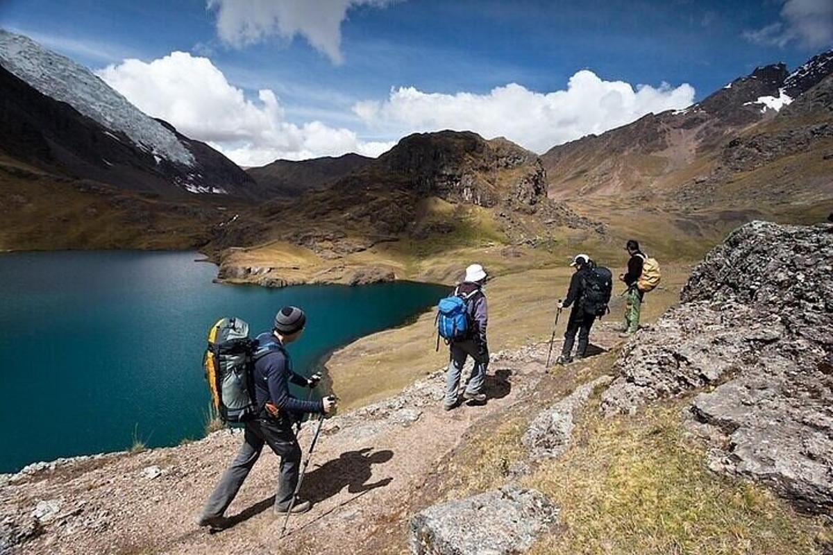 sekelompok orang berjalan di gunung dekat danau